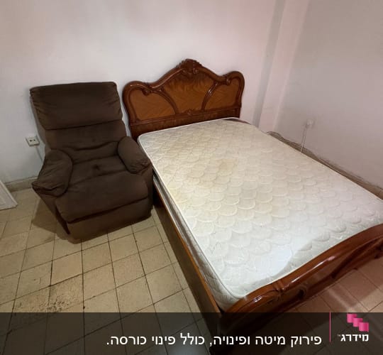 מיטה וכורסה בחדר ריק עם רצפת אריחים